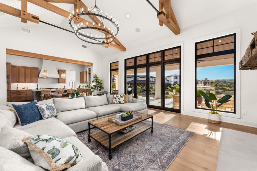 Living area with beam ceiling, high vaulted ceiling, light wood finished floors, a chandelier, and recessed lighting Living area with beam ceiling, high vaulted ceiling, light wood finished floors, a chandelier, and recessed lighting