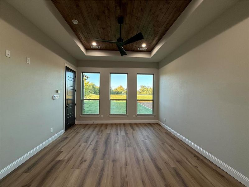 Spare room featuring wood ceiling, dark wood-style floors, recessed lighting, a tray ceiling, and a ceiling fan Spare room featuring wood ceiling, dark wood-style floors, recessed lighting, a tray ceiling, and a ceiling fan