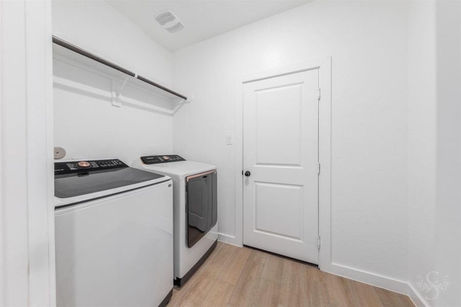 A spacious laundry room featuring a convenient upper shelf and hanging rod for additional storage. Its crisp, clean design makes everyday chores feel streamlined and efficient. A spacious laundry room featuring a convenient upper shelf and hanging rod for additional storage. Its crisp, clean design makes everyday chores feel streamlined and efficient.