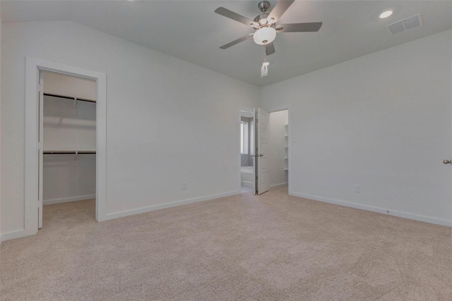 A spacious walk-in closet and private access to the luxurious en suite bath make this primary bedroom the ultimate owner’s retreat. Whether you're winding down after a long day or enjoying a lazy morning, this carpeted haven is both peaceful and practical with generous wall space for flexible furniture arrangements.