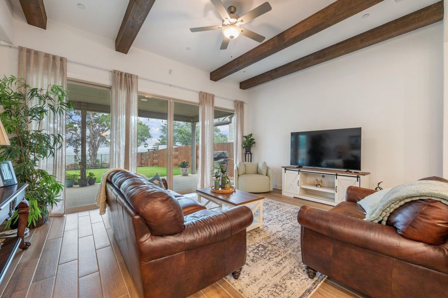 Exposed wood beams and vast glass doors frame this inviting living area with outdoor access. Exposed wood beams and vast glass doors frame this inviting living area with outdoor access.