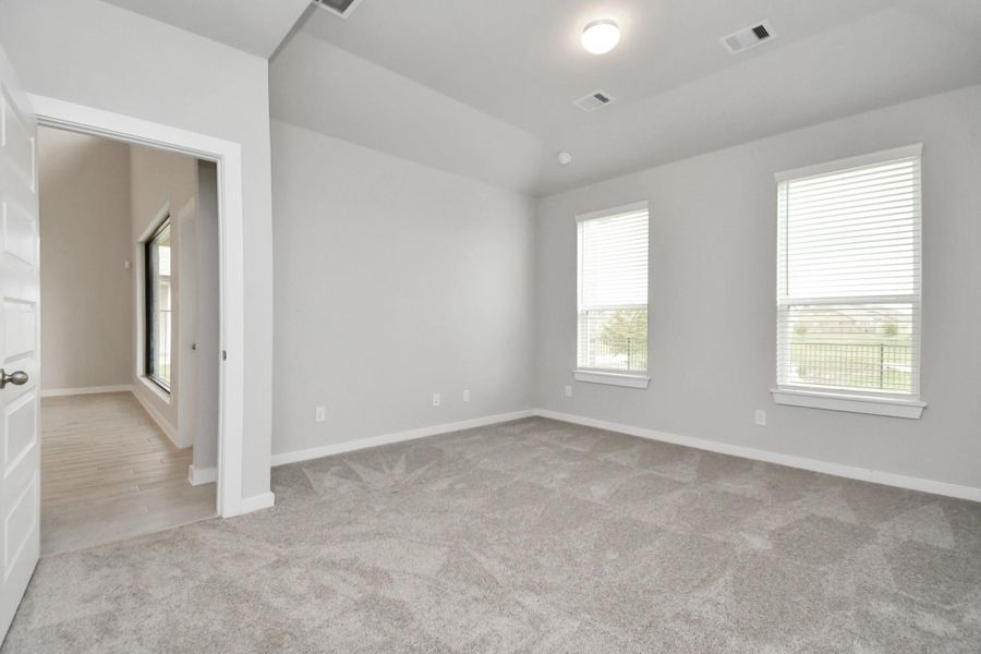 Unwind in style in this remarkable primary suite after a long day! Revel in the luxury of plush carpet, warm paint tones, soaring ceilings, and expansive windows featuring privacy blinds. Sample photo of completed home with similar floor plan. Actual colors and selections may vary. Unwind in style in this remarkable primary suite after a long day! Revel in the luxury of plush carpet, warm paint tones, soaring ceilings, and expansive windows featuring privacy blinds. Sample photo of completed home with similar floor plan. Actual colors and selections may vary.