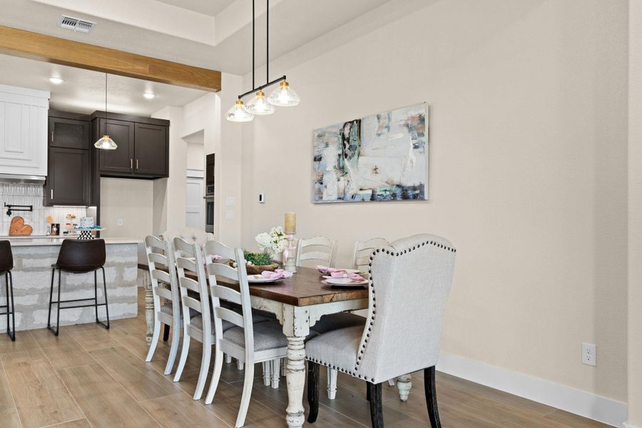 Dining space with light wood-style floors, beamed ceiling, and baseboards Dining space with light wood-style floors, beamed ceiling, and baseboards