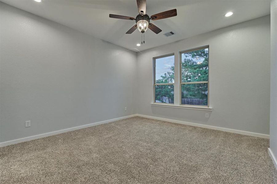 Second floor guest bedroom with large window overlooking the front yard.