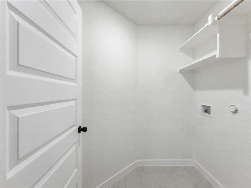 Laundry room with light gray floor tile, white walls, and built-in shelving Laundry room with light gray floor tile, white walls, and built-in shelving