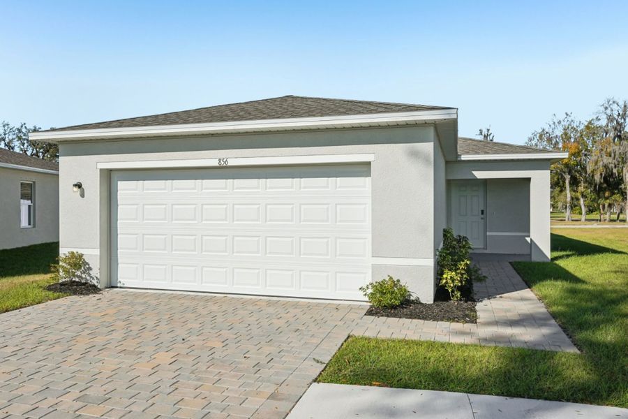 Front exterior of a new home in Belle Arbor, Labelle, FL, highlighting curb appeal (Image 1).