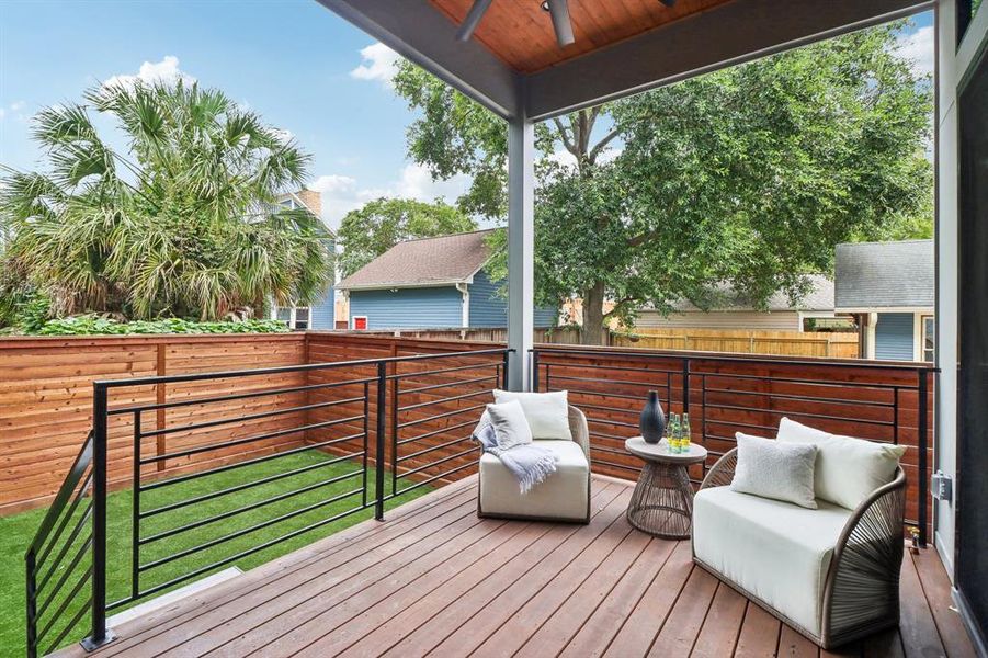 The rear porch and part of the backyard. Engineered wood, turf and a sealed, stained fence make this home able to withstand the climate.