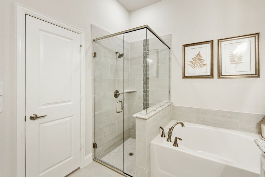 Bathroom with glass-enclosed tile shower, soaking tub, and brushed nickel fixtures Bathroom with glass-enclosed tile shower, soaking tub, and brushed nickel fixtures