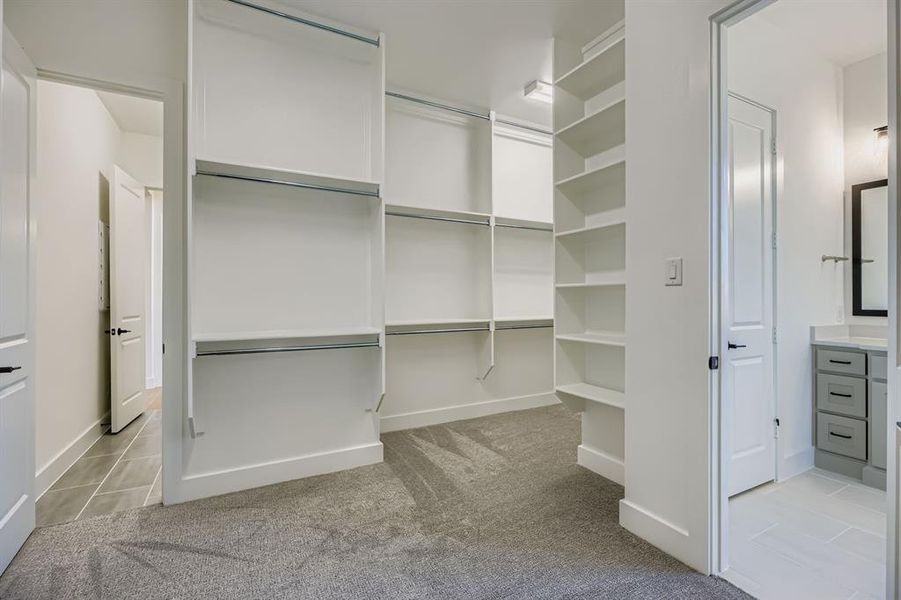 Spacious closet with light carpet and light tile patterned flooring