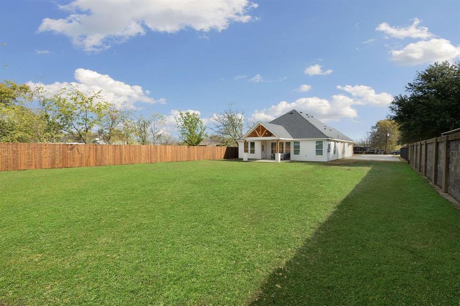 Rear view of property with a fenced backyard and a patio area Rear view of property with a fenced backyard and a patio area