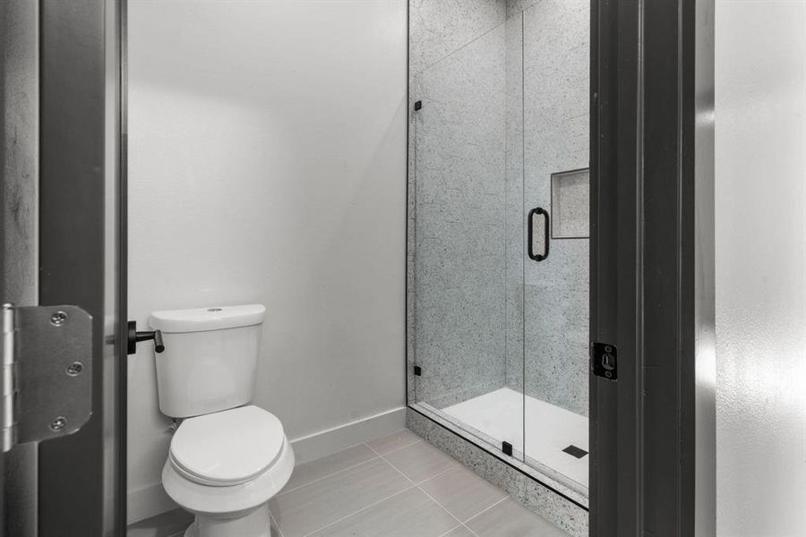 Bathroom with a shower stall and tile patterned flooring