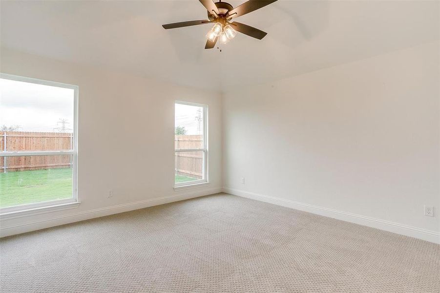 Unfurnished room with ceiling fan and light colored carpet