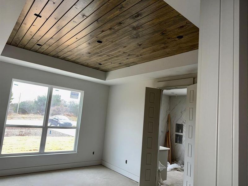 Spare room with wood ceiling, concrete floors, and a tray ceiling Spare room with wood ceiling, concrete floors, and a tray ceiling
