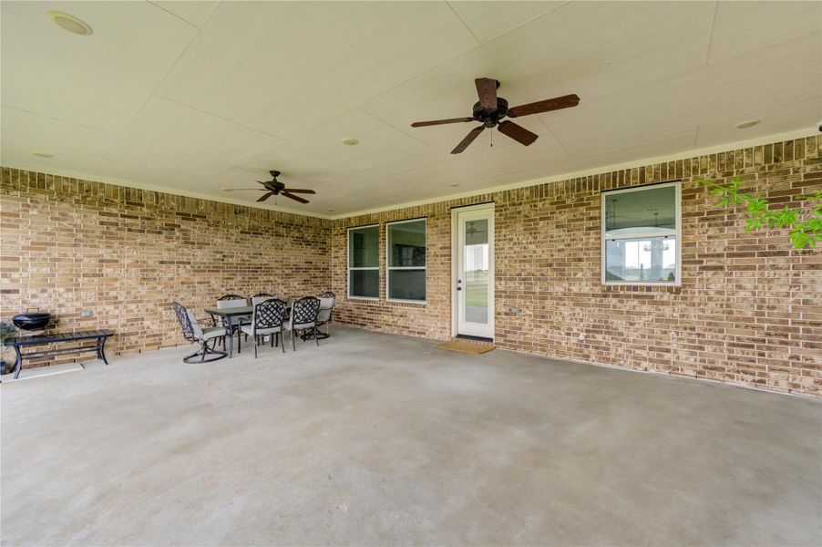Covered back patio with dual ceiling fans—perfect for outdoor dining and entertaining.