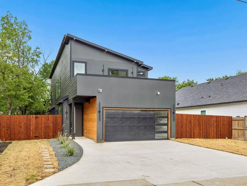 Contemporary facade featuring dark gray siding and a complementary wood-tone accent wall Contemporary facade featuring dark gray siding and a complementary wood-tone accent wall