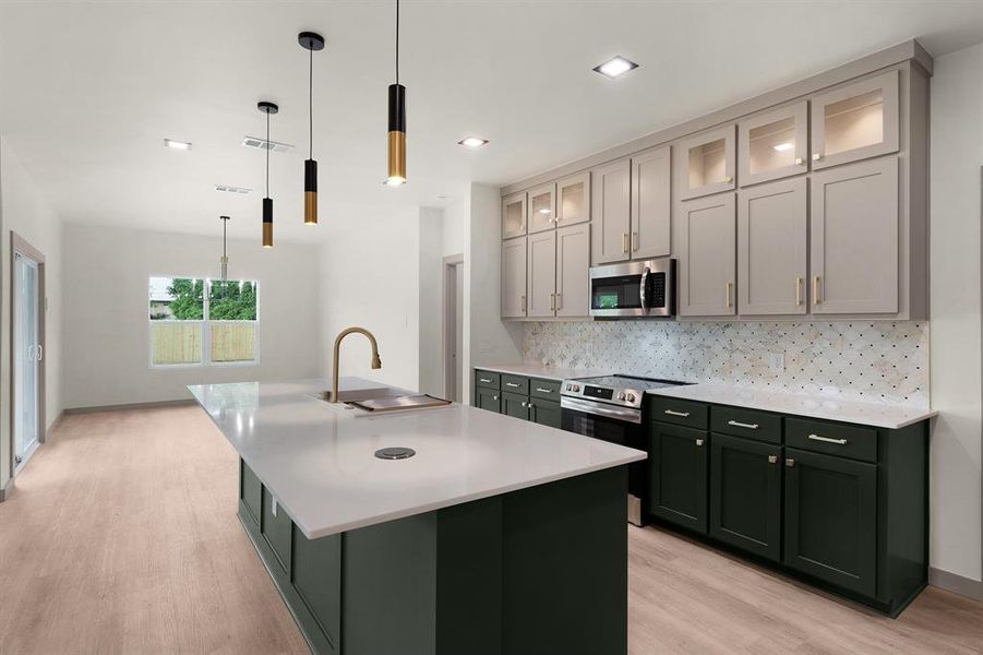 Kitchen featuring a sink, light wood-style floors, stainless steel appliances, backsplash, and visible vents