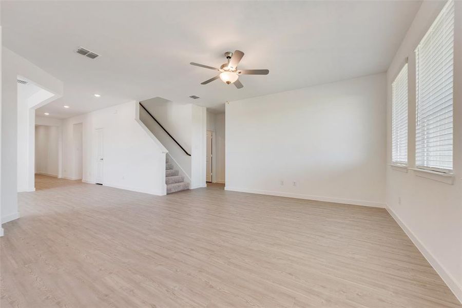 Unfurnished living room featuring light hardwood / wood-style floors and ceiling fan