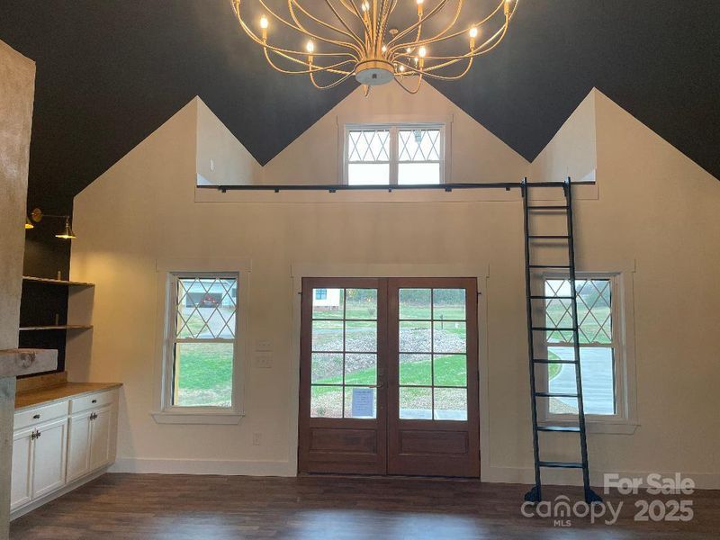 A Family Room like no other with designs from floor to ceiling, built-ins, custom loft with ladder above the front door, beautiful lighting and wood accents around the room.