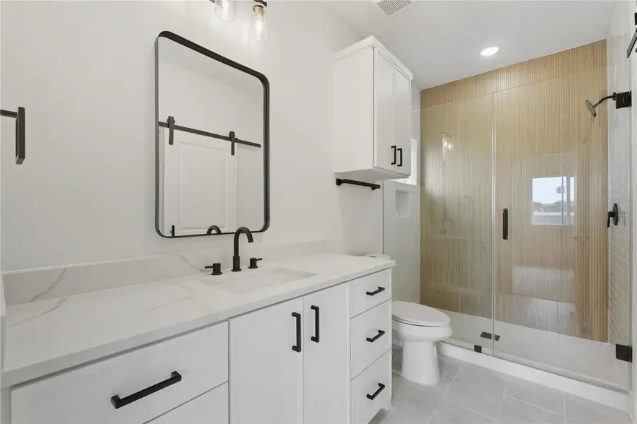 This ensuite bathroom gives you a space that feels like a personal spa. Start your mornings in the sleek walk-in shower, and enjoy the modern finishes, quartz counters, black hardware, and plenty of storage. It’s as functional as it is beautiful, giving you a space to relax and refresh every day!