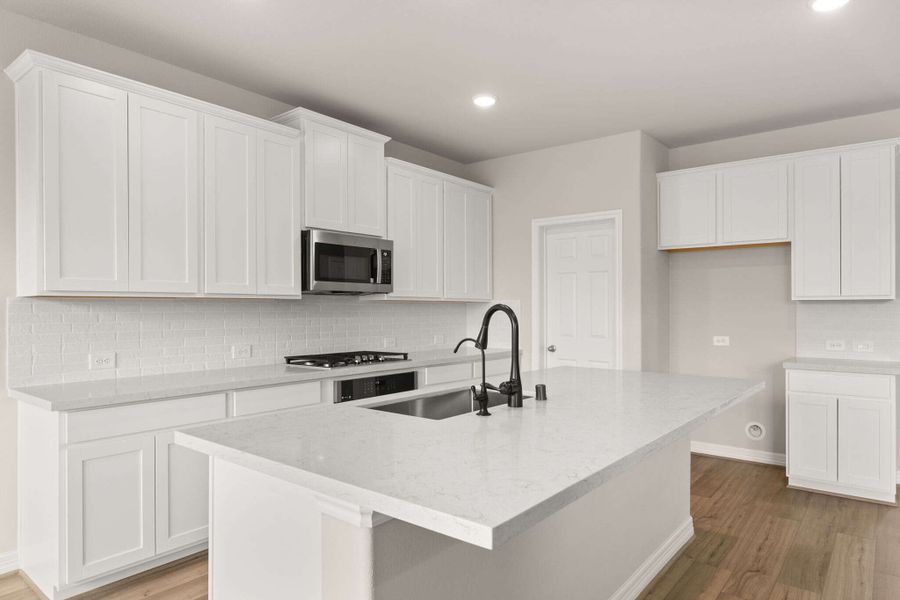 The kitchen has a large center island with overhang perfect for a breakfast bar.