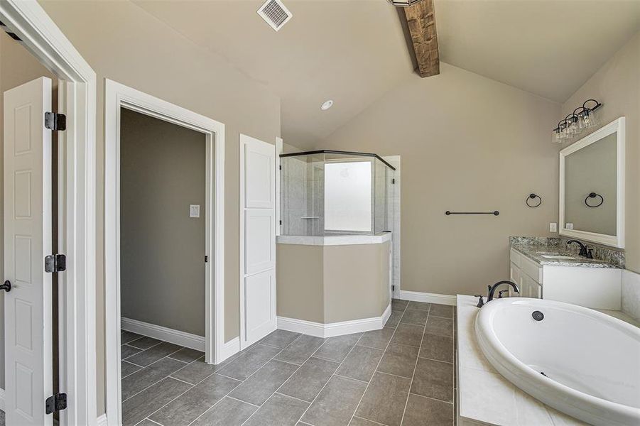 Bathroom featuring tile patterned flooring, vaulted ceiling with beams, vanity, and shower with separate bathtub