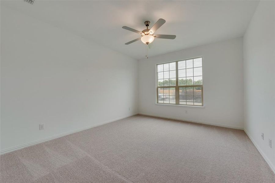 Carpeted spare room with ceiling fan