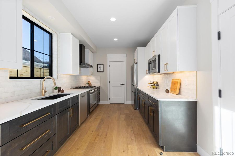 Two-tone tuxedo cabinetry with gold hardware,state of the art appliances and walk-in pantry Two-tone tuxedo cabinetry with gold hardware,state of the art appliances and walk-in pantry