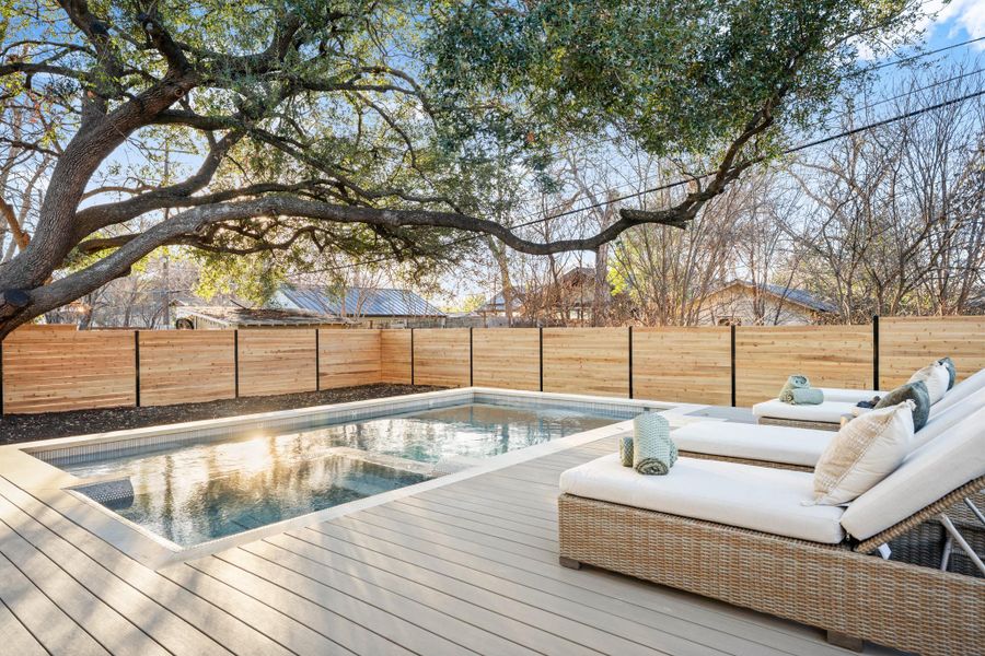 View of pool featuring a fenced backyard and a deck