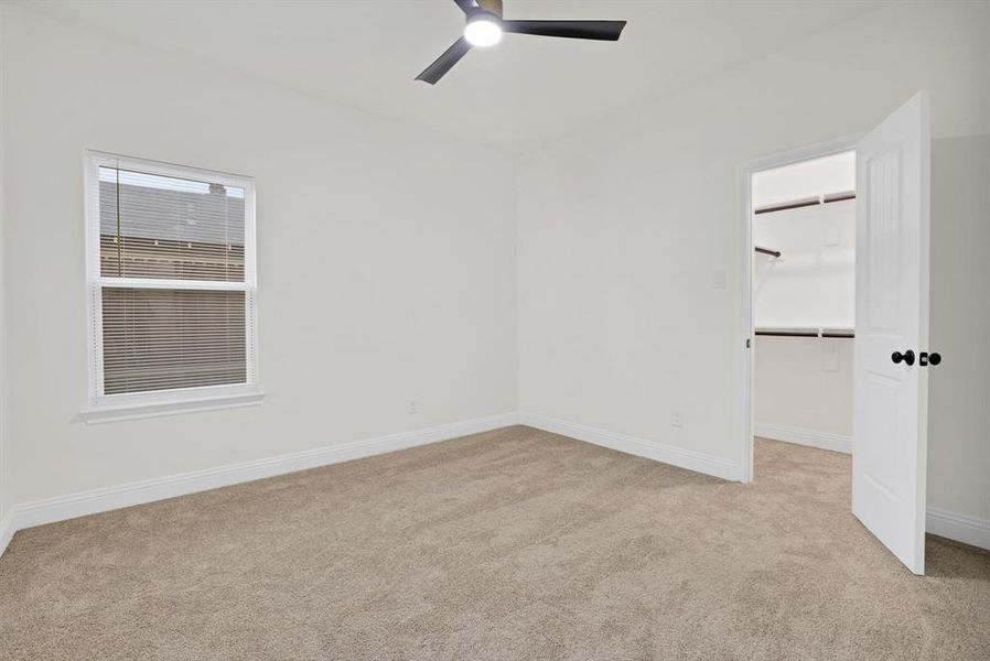 Spare room featuring light carpet and ceiling fan