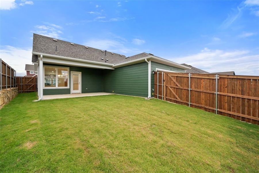 Rear view of property with a lawn and a patio area