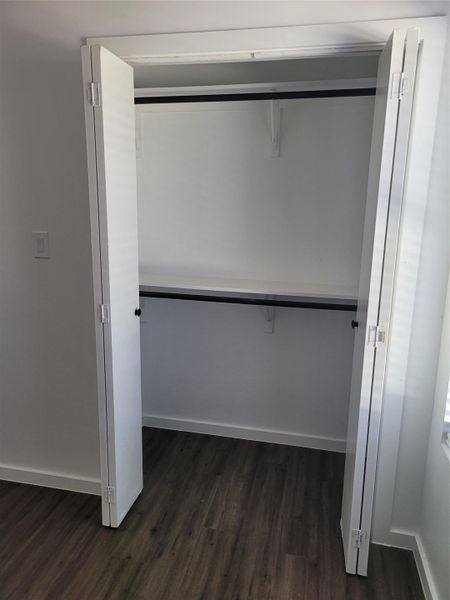 Ample storage solutions await within this well-appointed closet, featuring durable wood-look flooring.