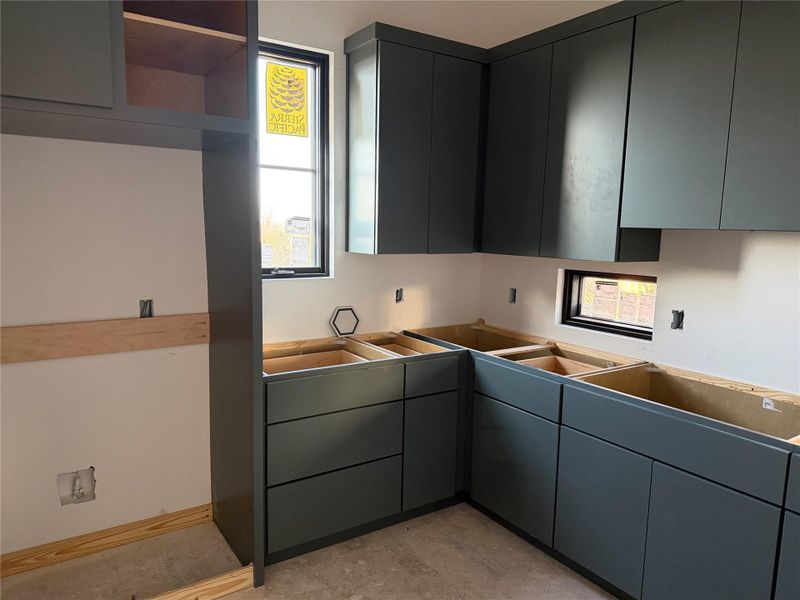 Kitchen featuring plenty of natural light, open shelves, and concrete floors