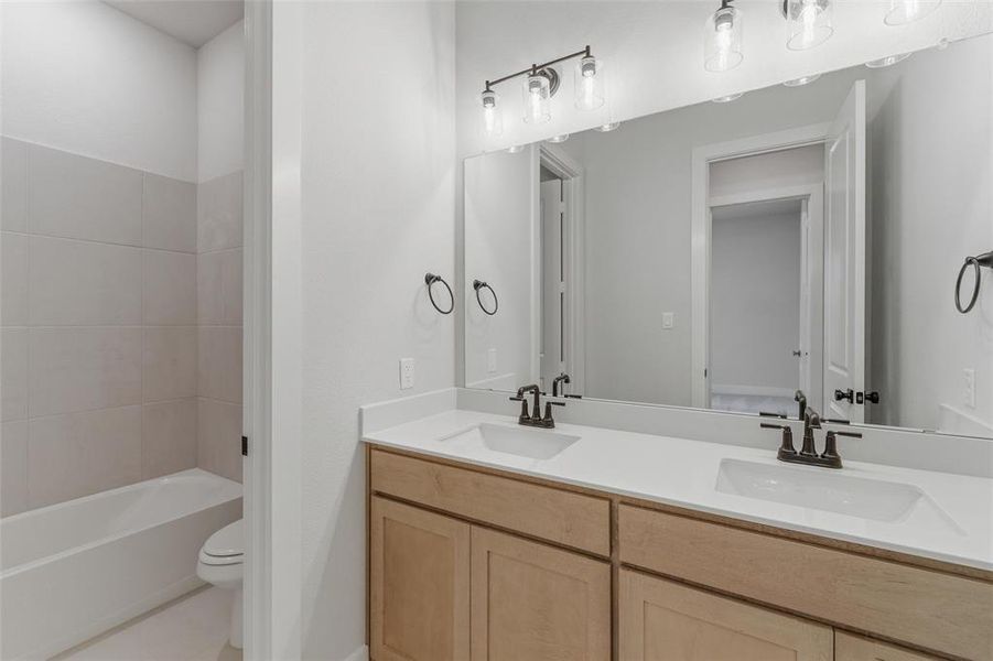 Bathroom featuring double vanity and light tile patterned floors Bathroom featuring double vanity and light tile patterned floors