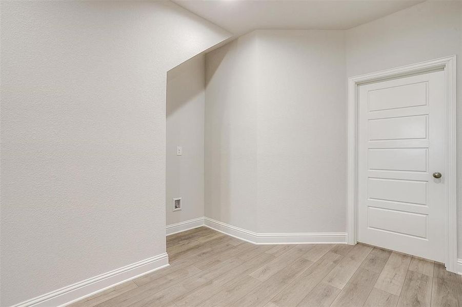 Additional living space featuring light wood-style flooring and baseboards