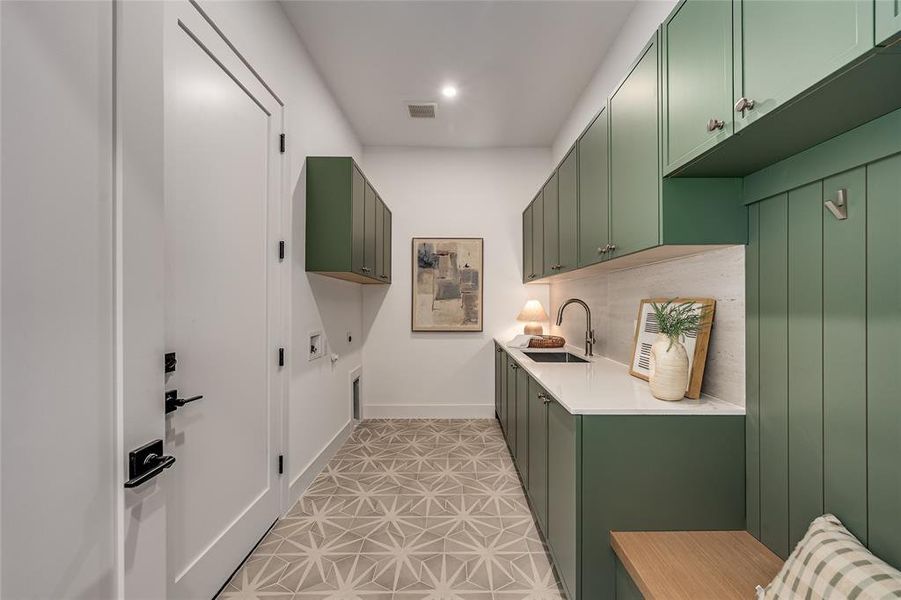 Laundry room featuring cabinet space, hookup for a washing machine, and light tile patterned floors Laundry room featuring cabinet space, hookup for a washing machine, and light tile patterned floors