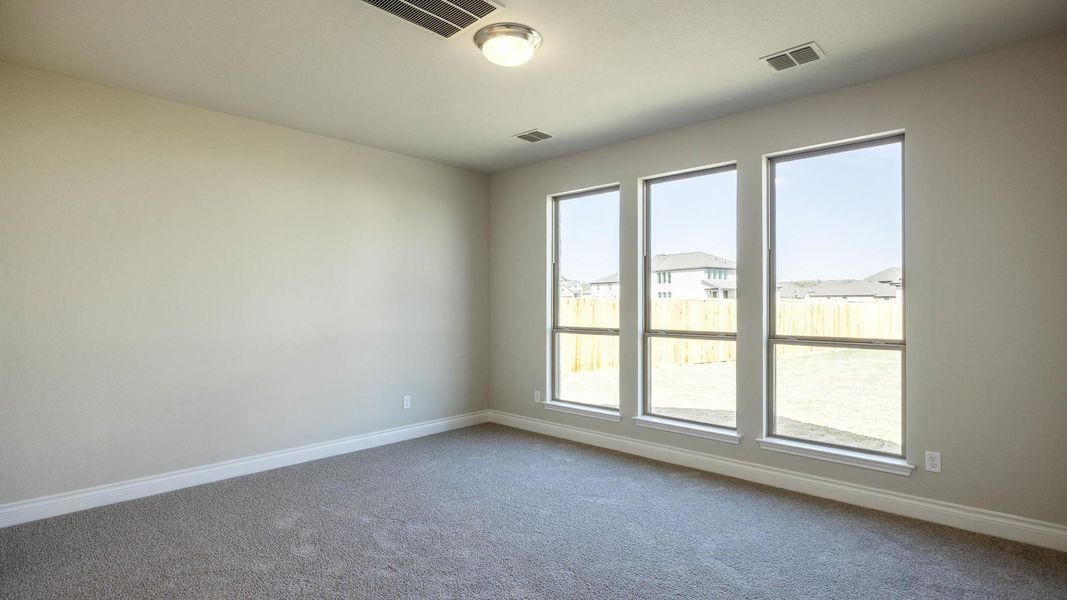 Carpeted spare room with baseboards and visible vents Carpeted spare room with baseboards and visible vents