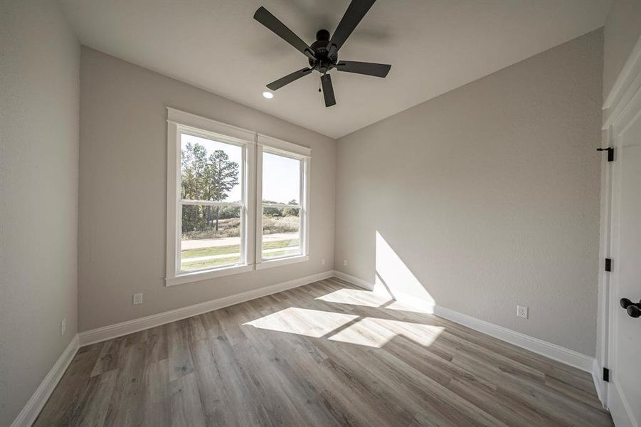 Empty room with light wood-style floors, a ceiling fan, and vaulted ceiling Empty room with light wood-style floors, a ceiling fan, and vaulted ceiling