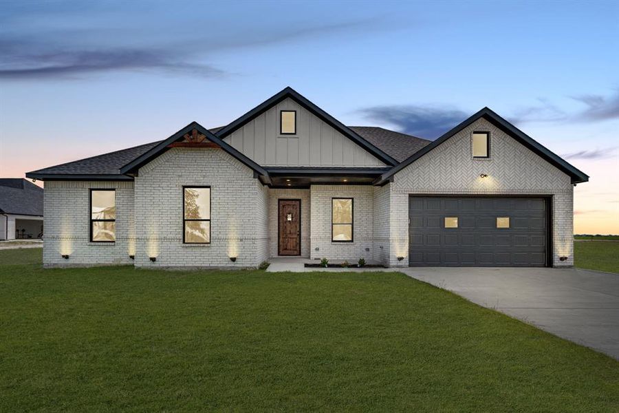 Modern inspired farmhouse featuring a garage and a yard