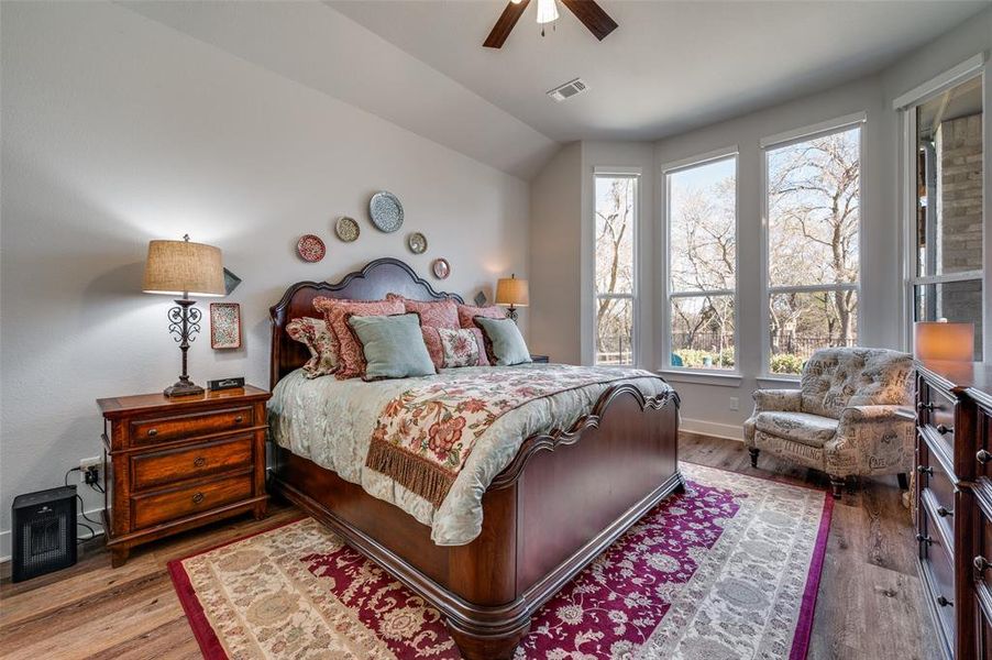 Bedroom featuring hardwood / wood-style floors, a ceiling fan, and vaulted ceiling