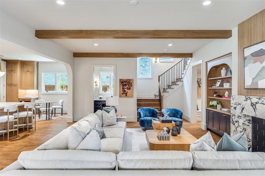 Living room with recessed lighting, arched walkways, built in shelves, stairs, and light wood-type flooring Living room with recessed lighting, arched walkways, built in shelves, stairs, and light wood-type flooring