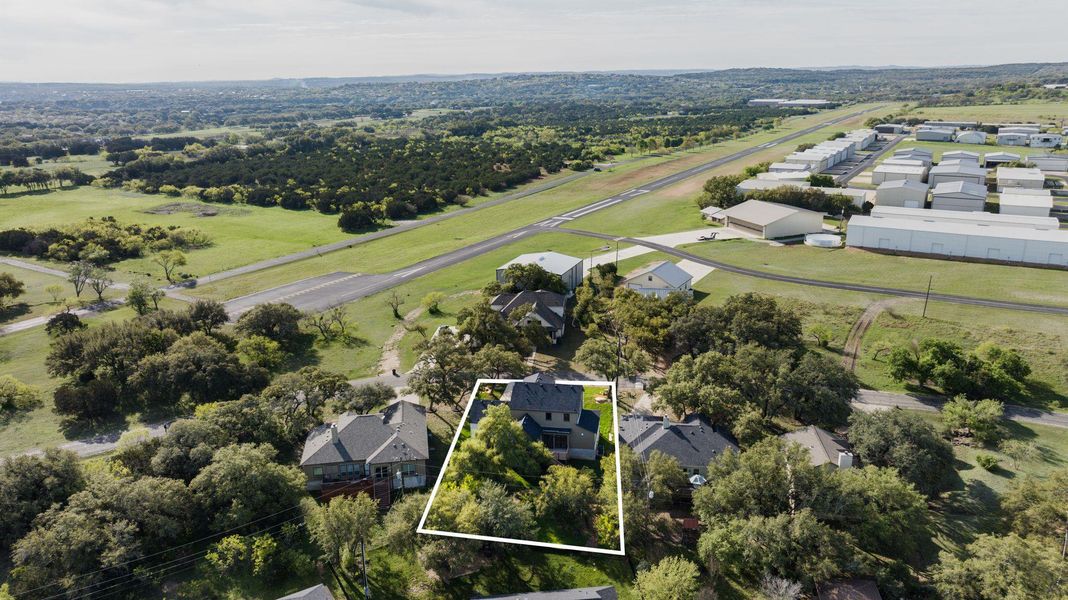 Aerial view of residential area featuring property parcel outlined and a tree filled landscape Aerial view of residential area featuring property parcel outlined and a tree filled landscape