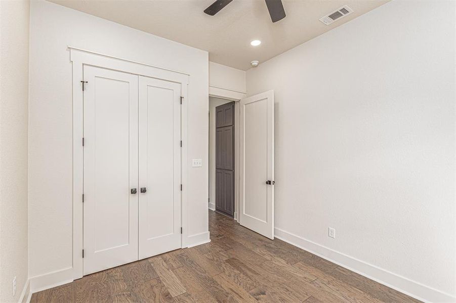 Unfurnished bedroom with dark wood-style floors, a closet, ceiling fan, and recessed lighting