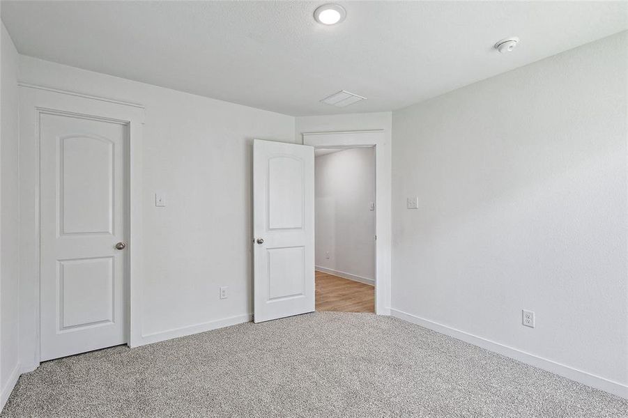 Unfurnished bedroom featuring light colored carpet