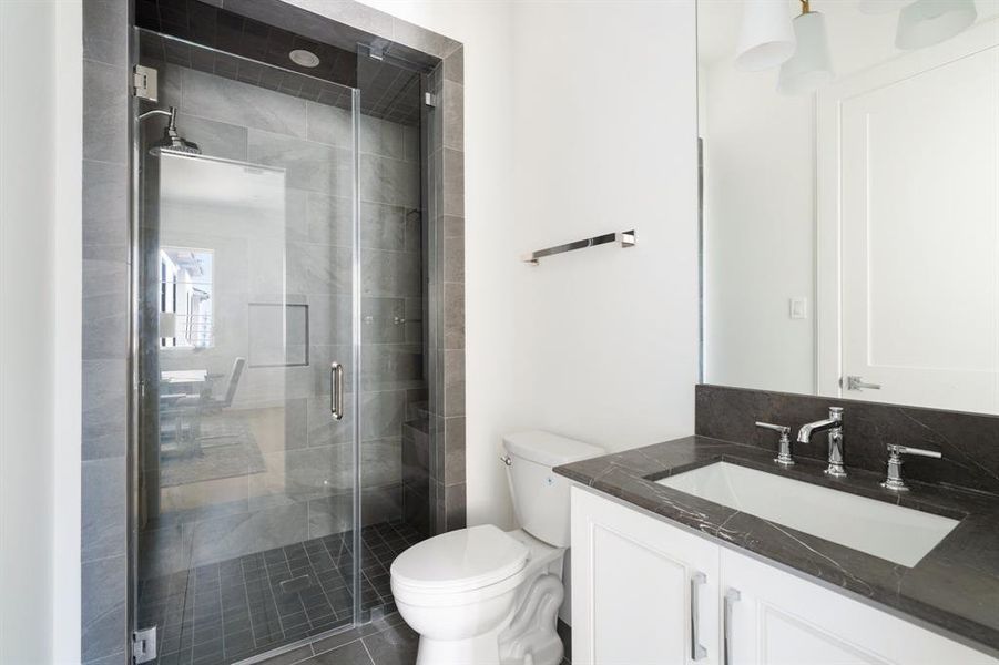 Shared between the bedroom and game room, this bathroom offers dual access points from both spaces. (photo of interior model home with smaller floor plan)