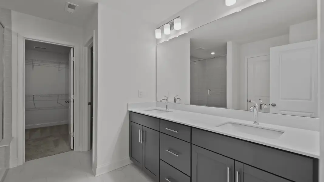 Burton Design bathroom with dual-sink vanity with easy access to walk-in closet. By DRB Homes at Lakeside Glen, York, SC. Burton Design bathroom with dual-sink vanity with easy access to walk-in closet. By DRB Homes at Lakeside Glen, York, SC.