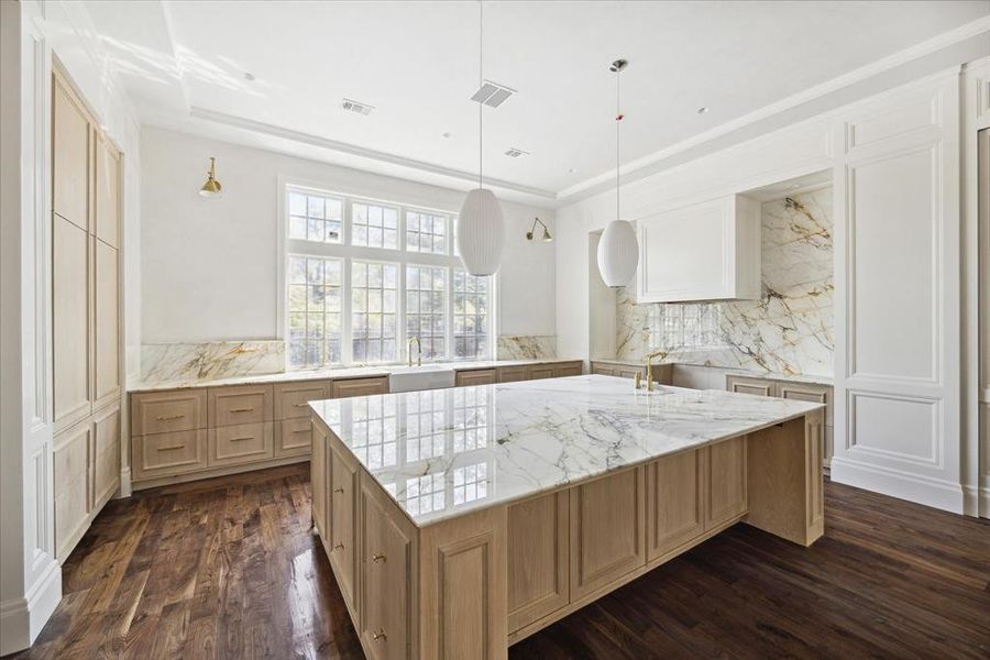 The beautiful backsplash, counter tops, and white oak cabinetry exudes luxury.