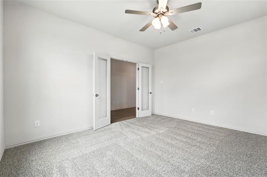 Carpeted spare room featuring baseboards and ceiling fan