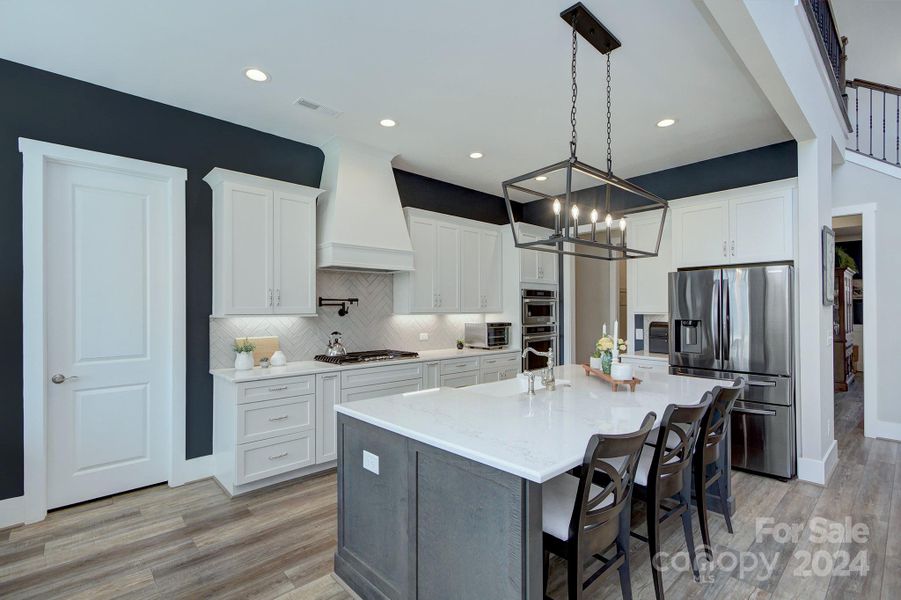 This open kitchen layout offers great prep/counter space, large kitchen island and upgraded lighting