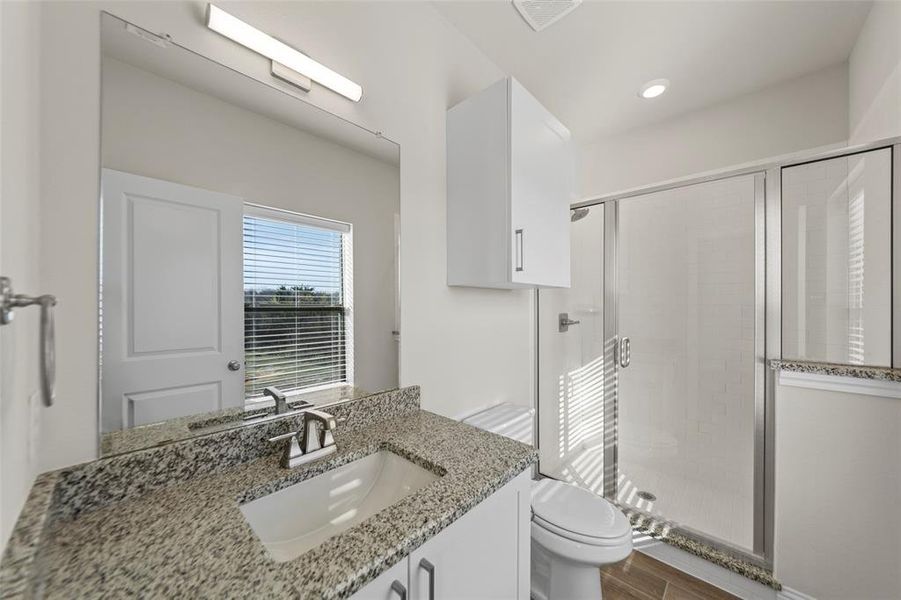 Bathroom with a shower stall, vanity, dark wood-style floors, and recessed lighting