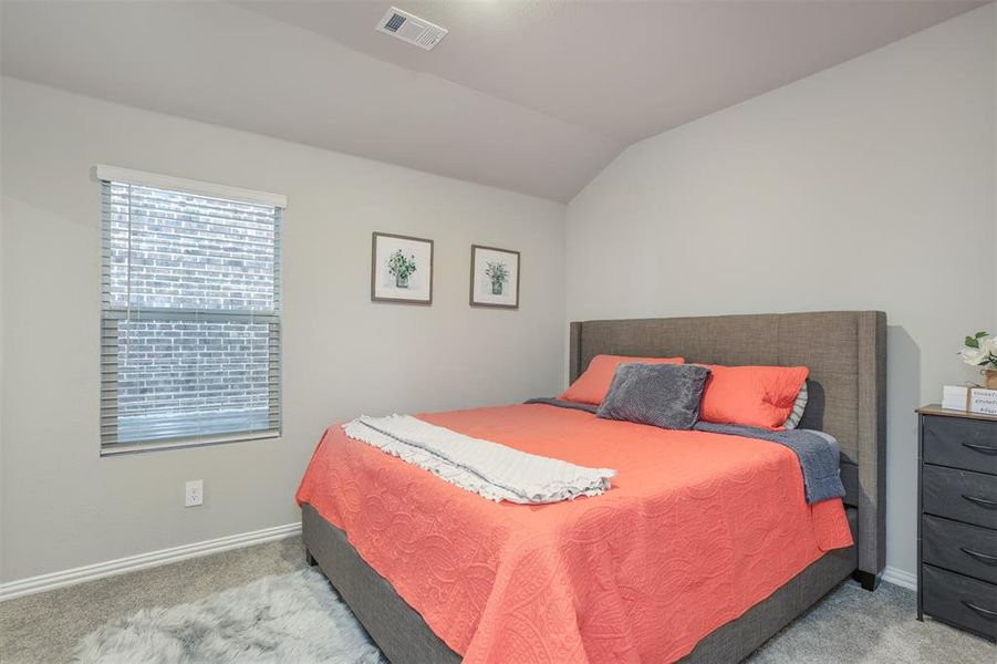Bedroom featuring carpet flooring and vaulted ceiling Bedroom featuring carpet flooring and vaulted ceiling